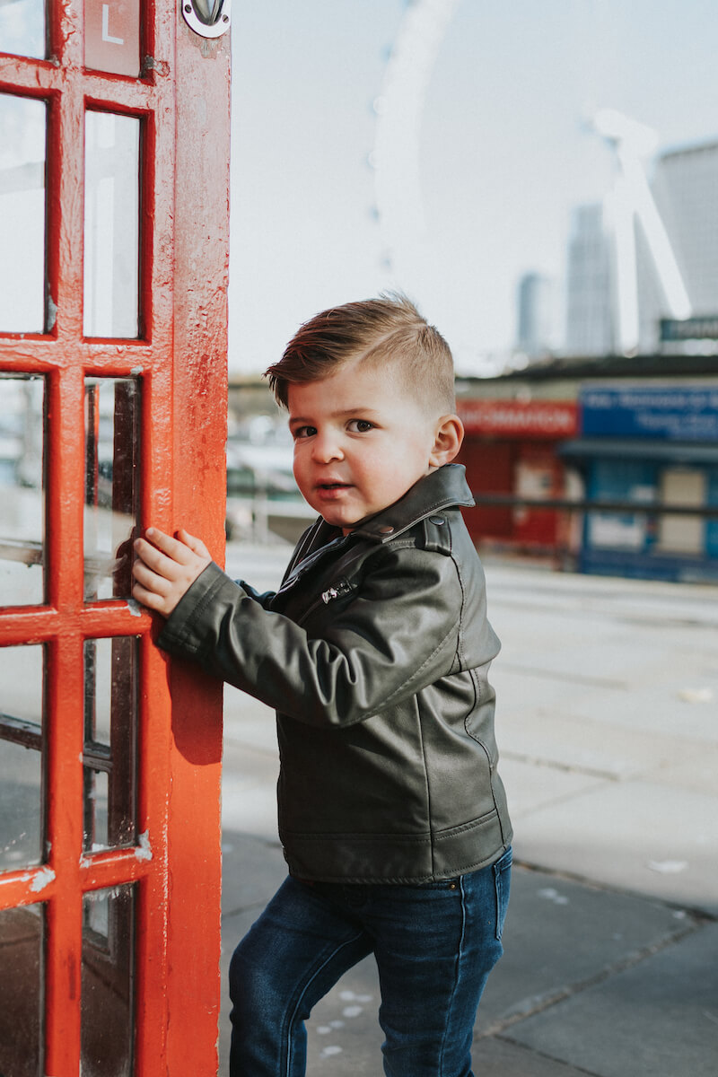a small boy is going into a phone booth in London, England
