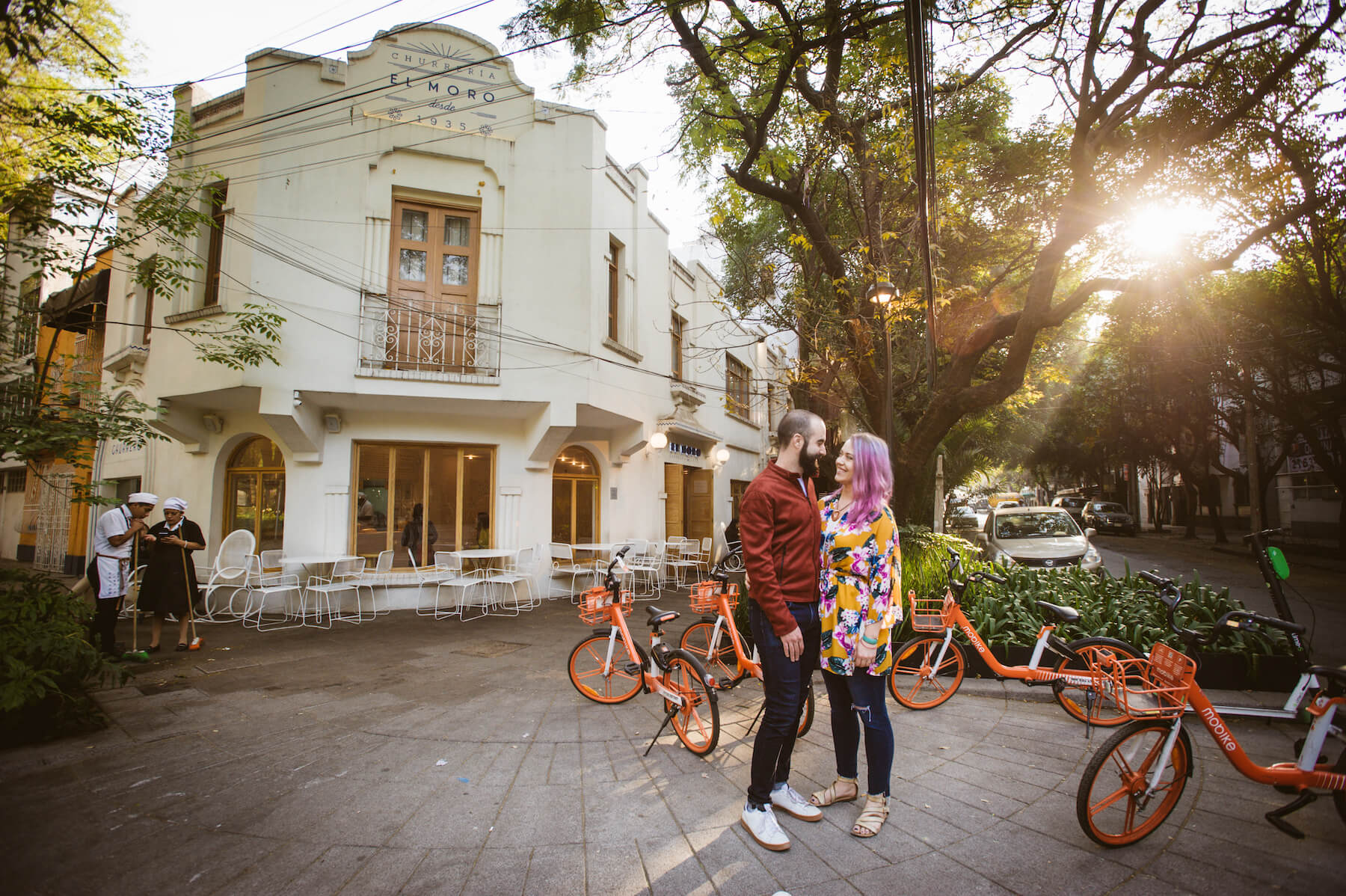 couple standing in the street in front of colorful orange bikes in Mexico City, Mexico