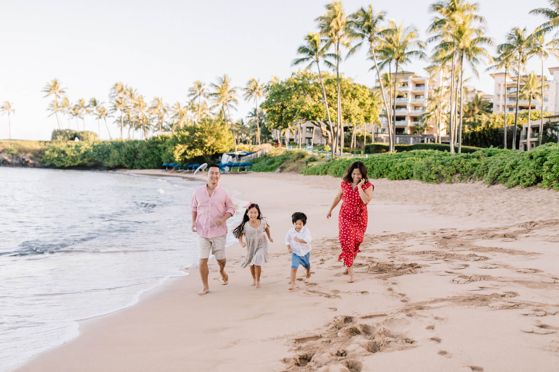 family of four running on the beach in Maui, Hawaii