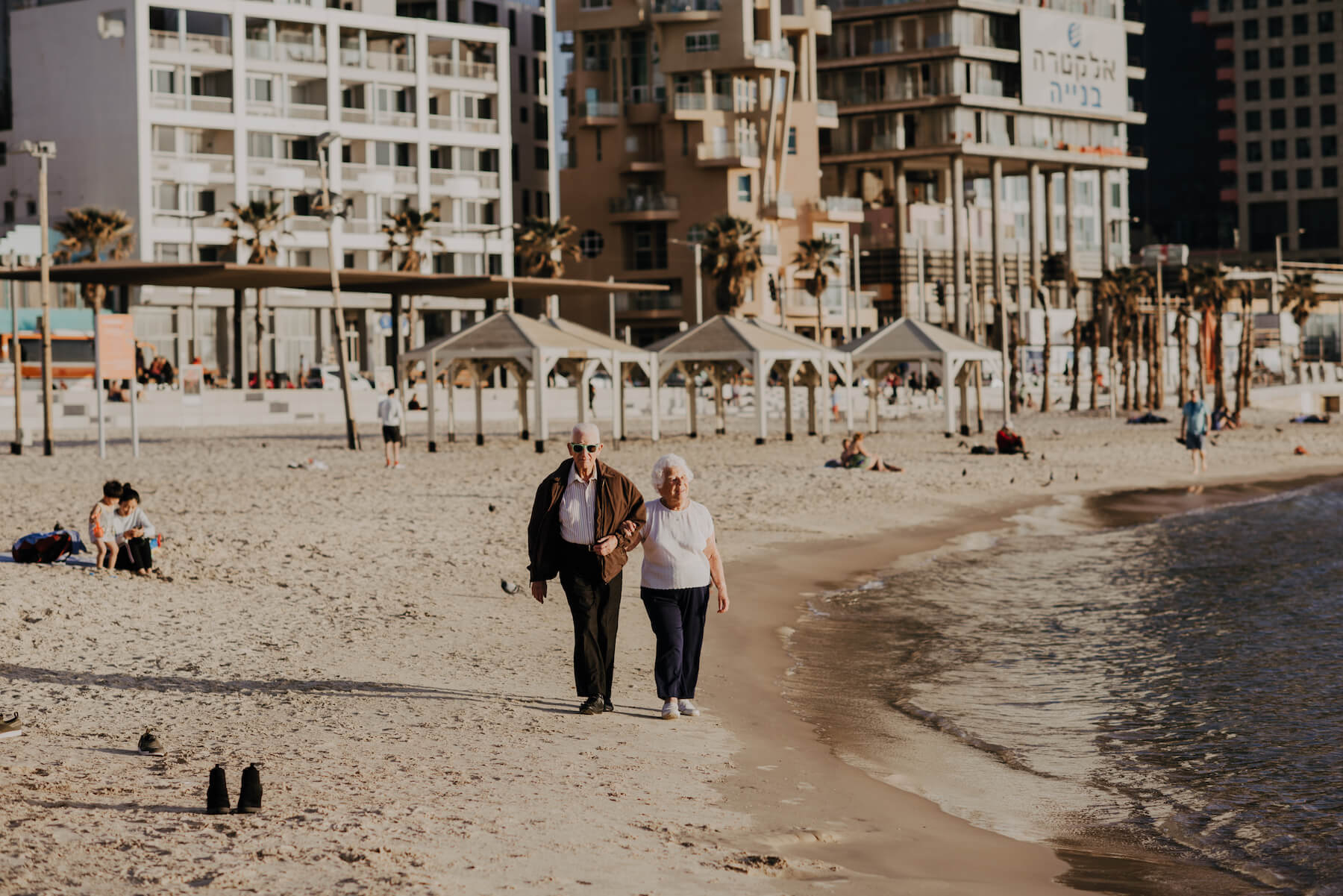 Older couple walking on the beach in Tel Aviv, Israel