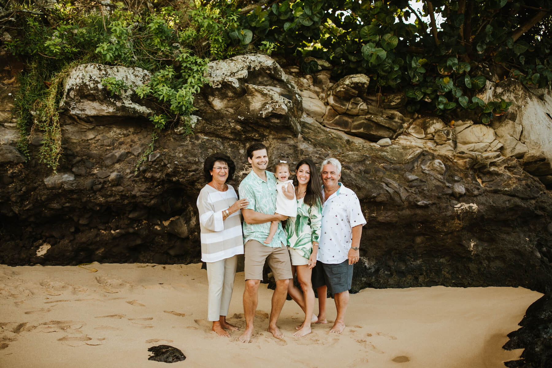 grandparents with their children and grandchild on the beach in Maui, Hawaii
