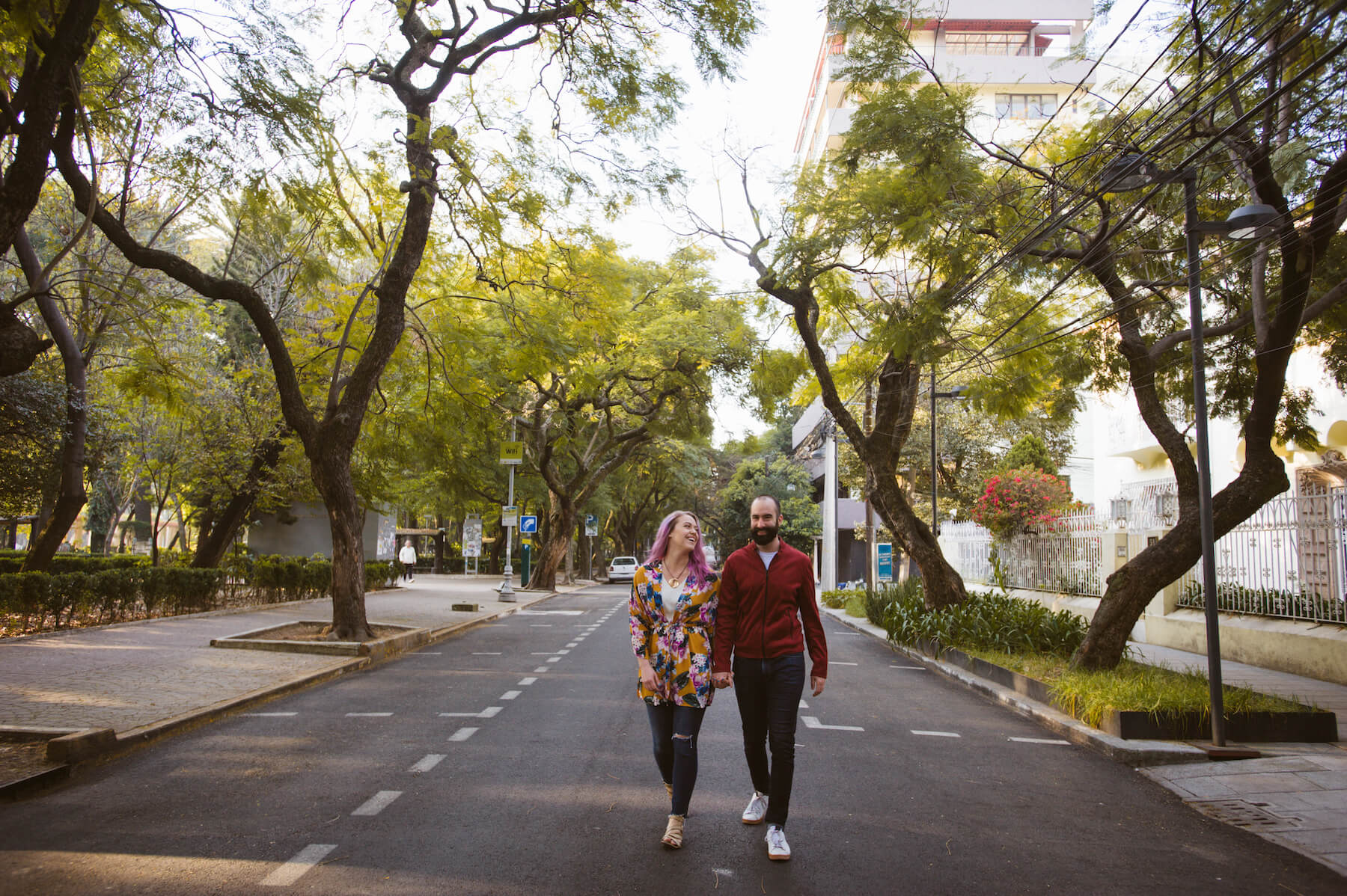 couple holding hands and walking down the middle of a road in Mexico City, Mexico