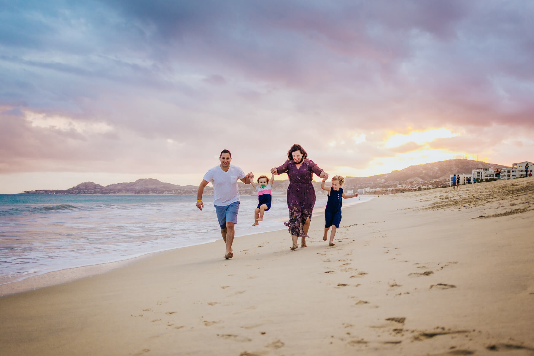 family of four, lifting one of the kids on the beach in Cabo San Lucas, Mexico