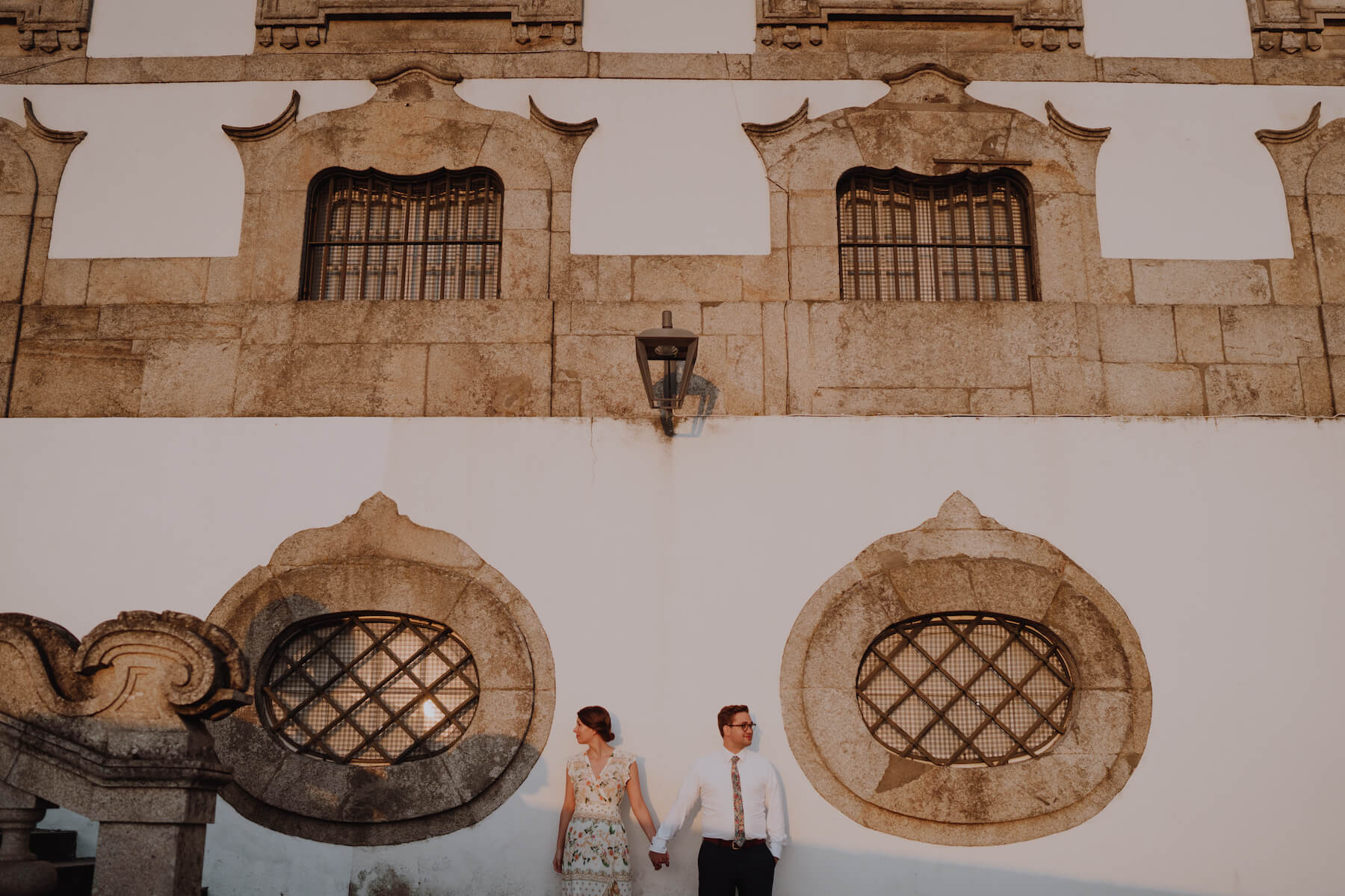 couple standing in front of a colorful building in Porto, Portugal