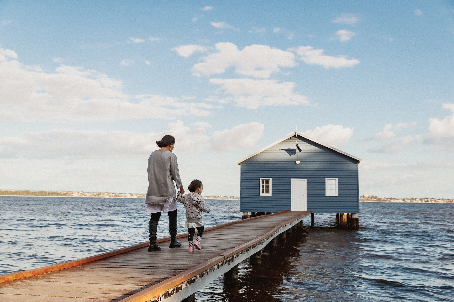Mother and daughter walking on a dock in Perth Australia