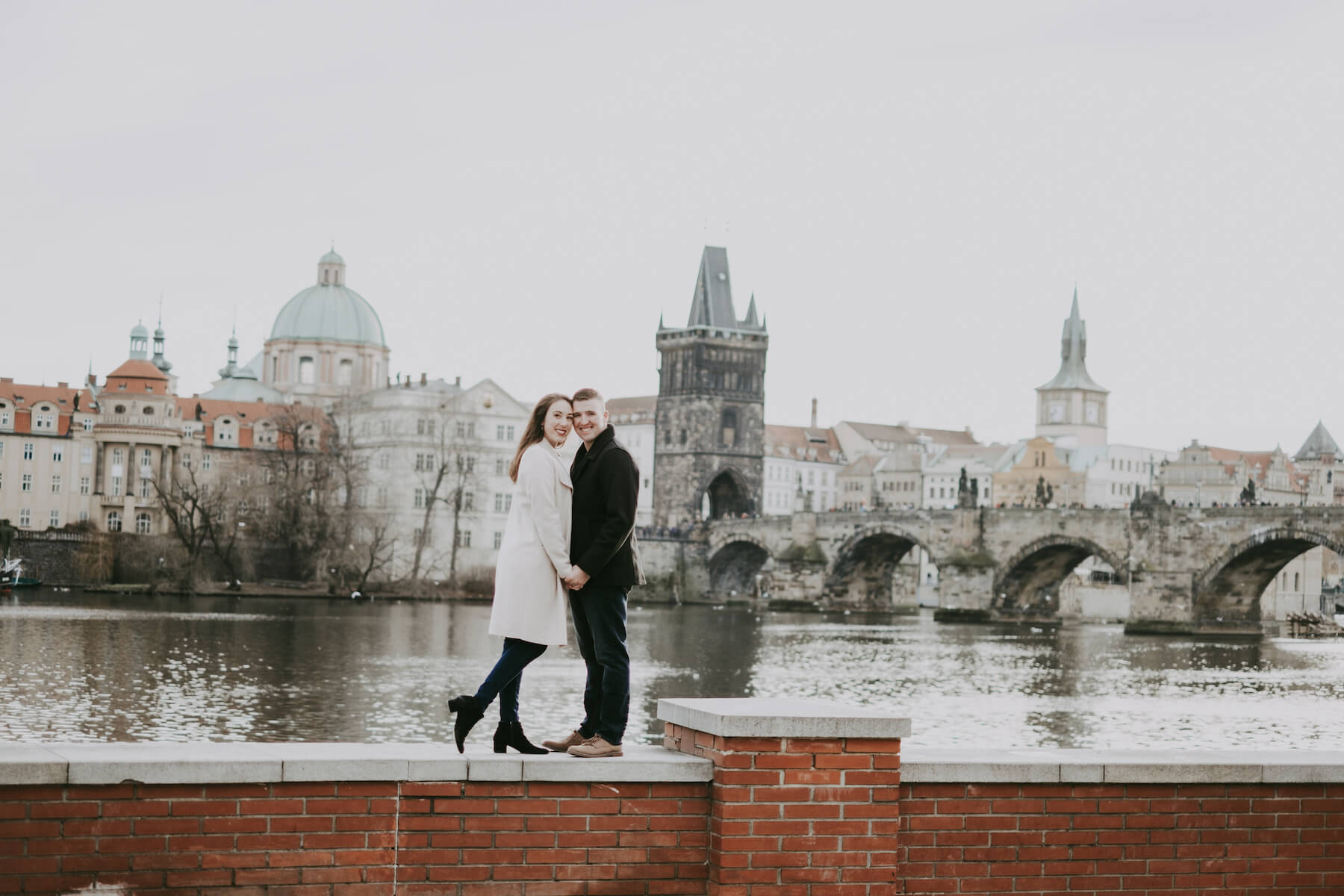 Couple in front of the Charles Bridge in Prague Czech Republic