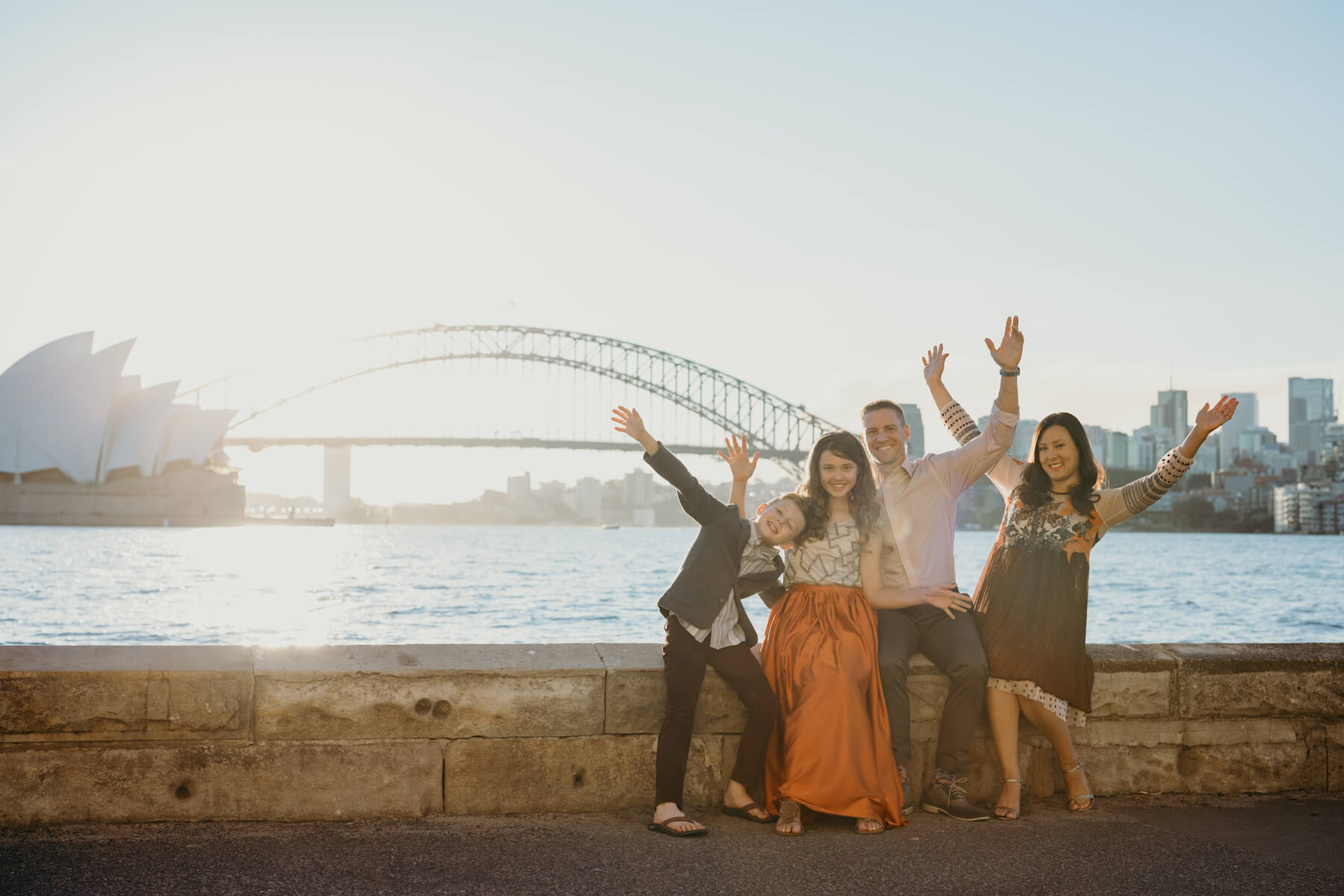 Family of 4 excited in front of the Sydney opera house in Australia