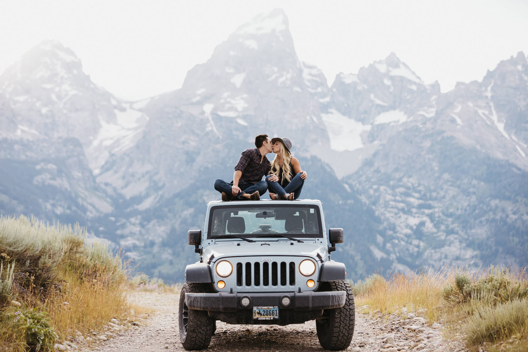Couple kissing on a jeep in Jackson Hole on a Flytographer photo shoot