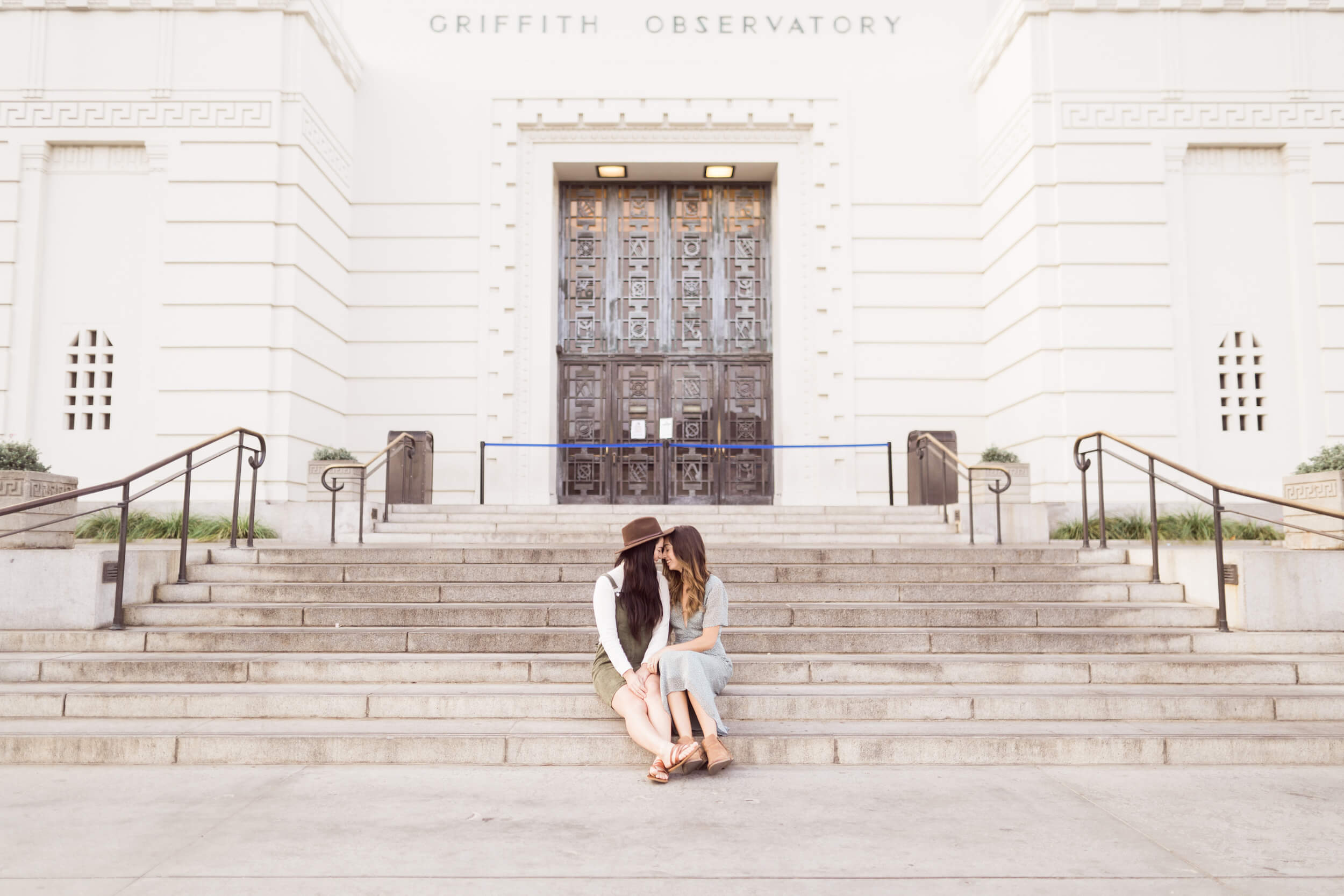 A female couple snuggles on the steps of the Griffith Observatory in Los Angeles, USA.