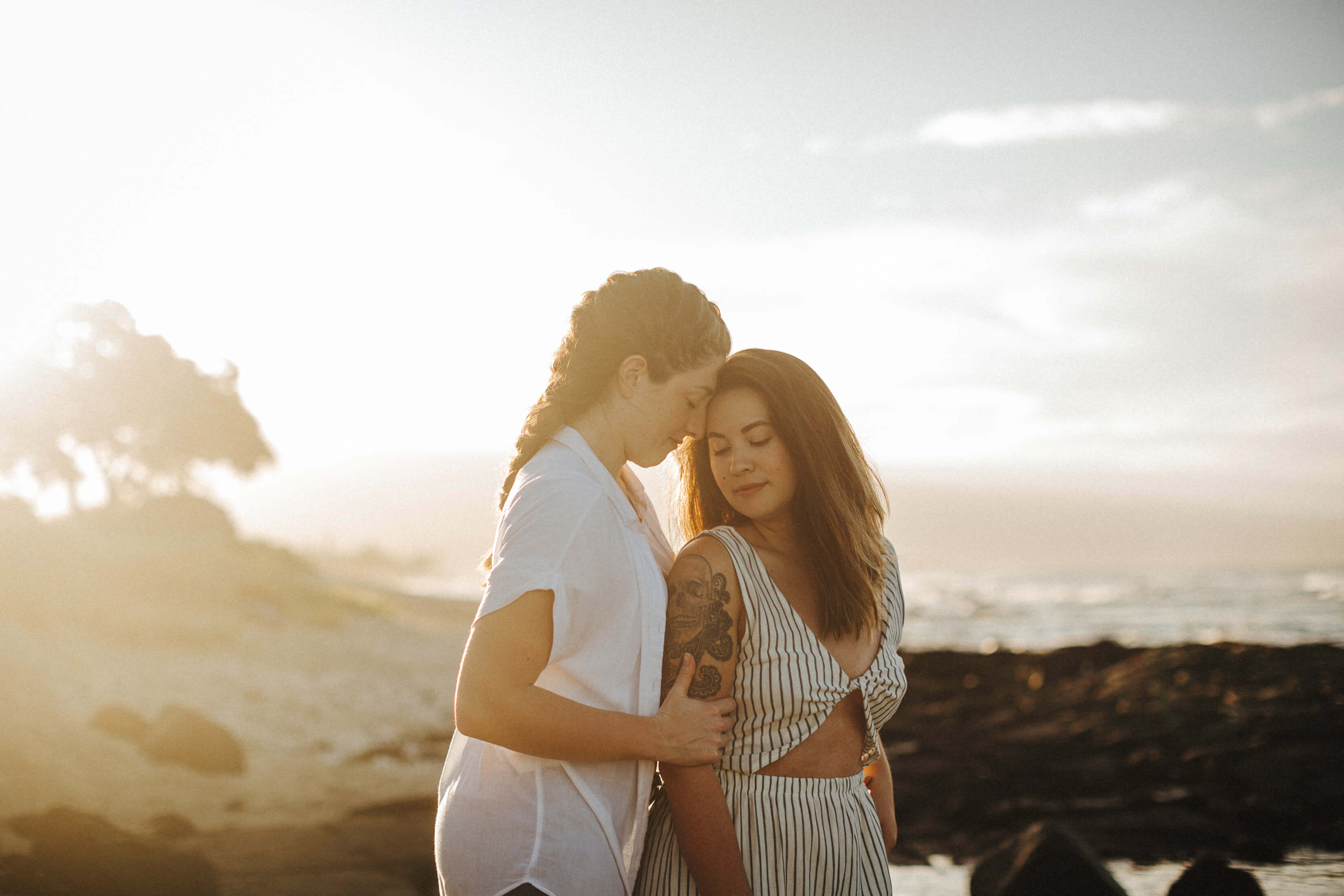A couple embraces on the beach in Kona, Hawaii, USA.