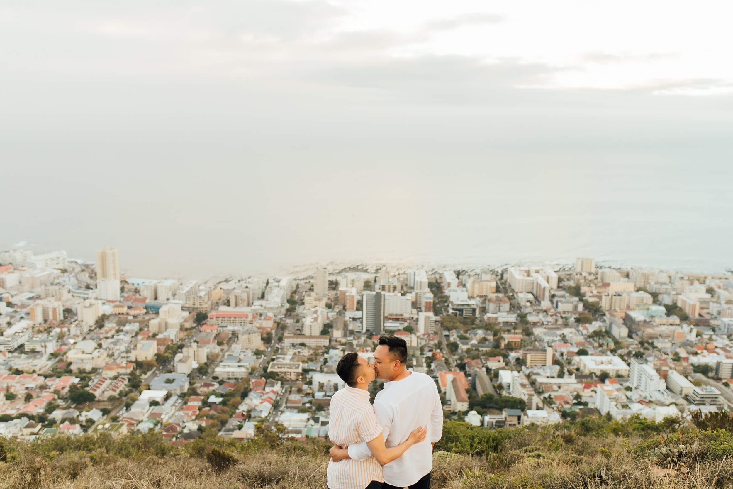 Two men kiss after getting engaged atop a hill overlooking Cape Town, South Africa.