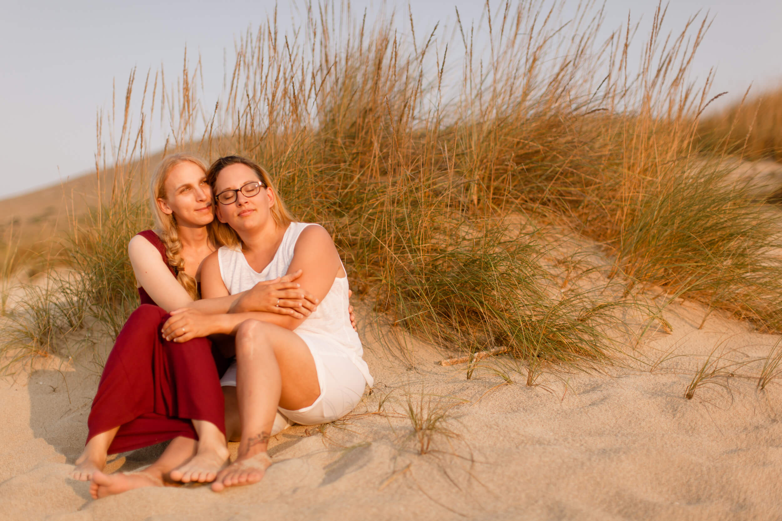 A female couple sits on the beach in Palma de Mallorca, Spain.