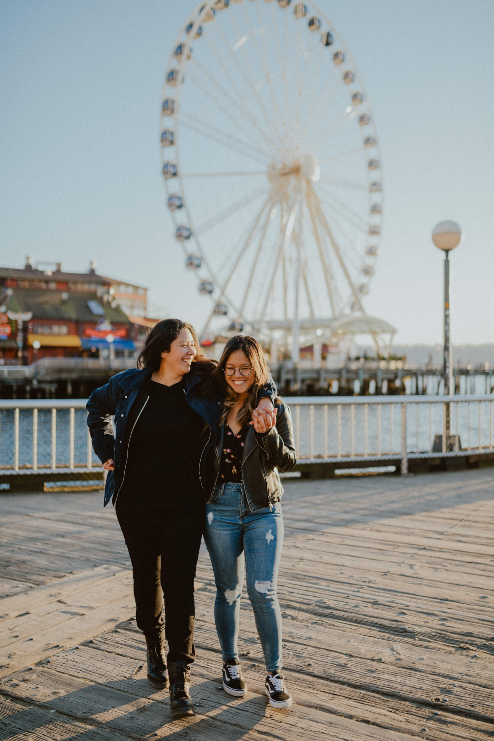 a couple hugs while walking on the boardwalk in Seattle, USA.