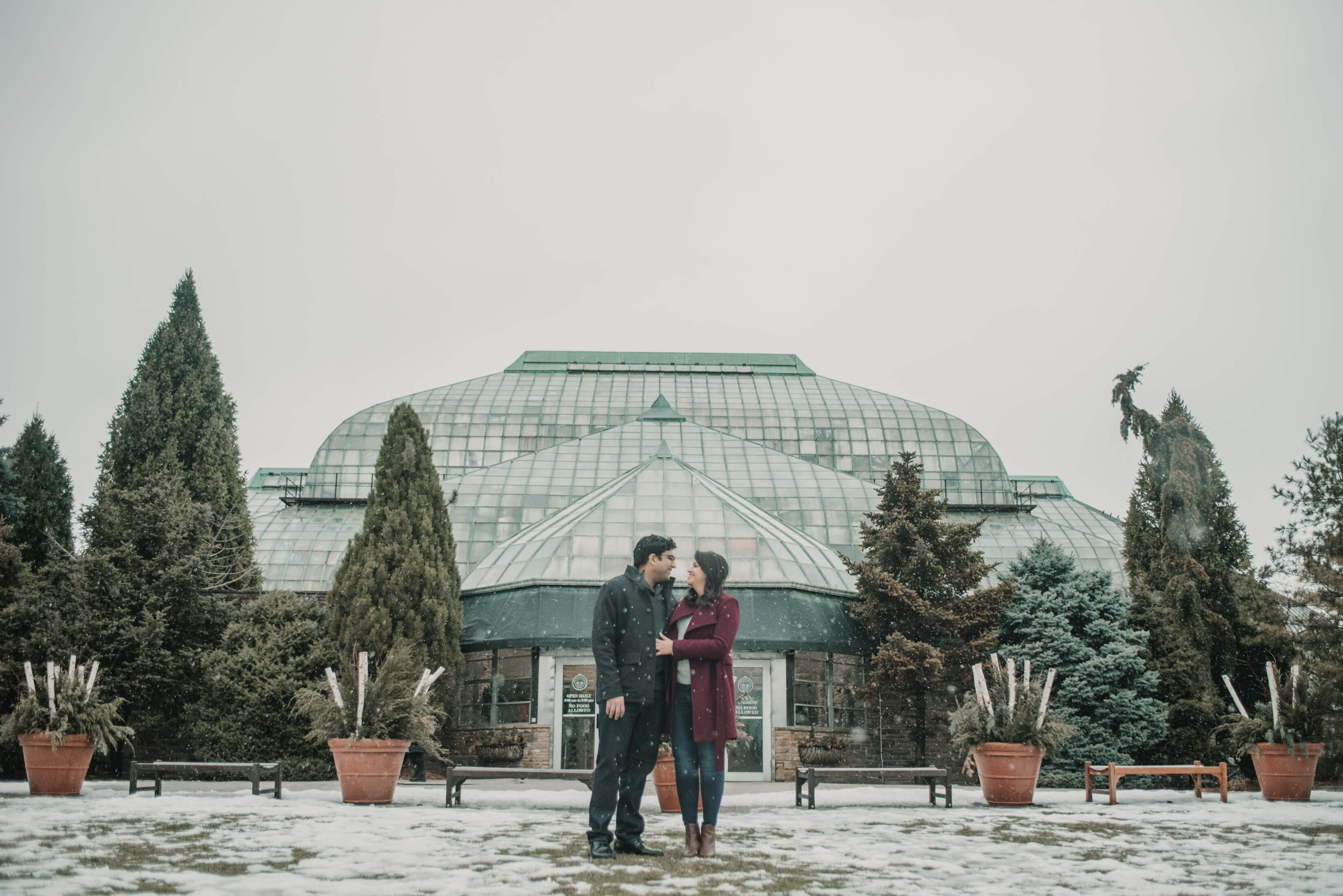couple sitting on a ledge with the Eiffel tower in the background in Paris, France