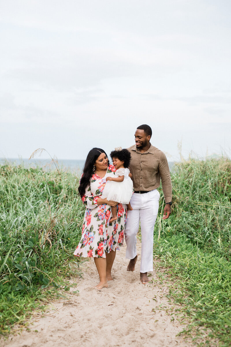 Family of 3 walking down the beach in Ft. Lauderdale, Florida