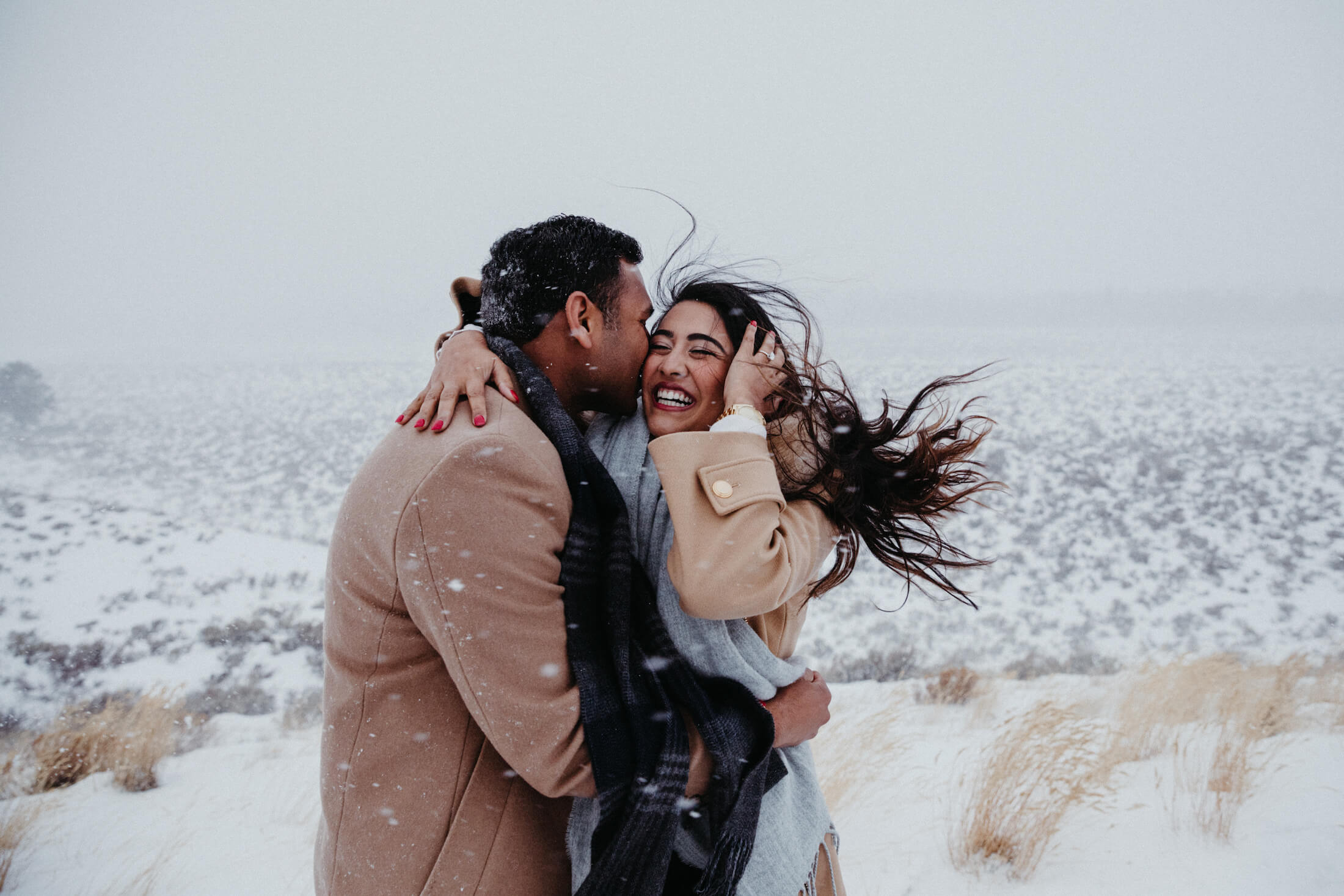 Couple holding and hugging each other in the snow in Jackson Hole, Wyoming