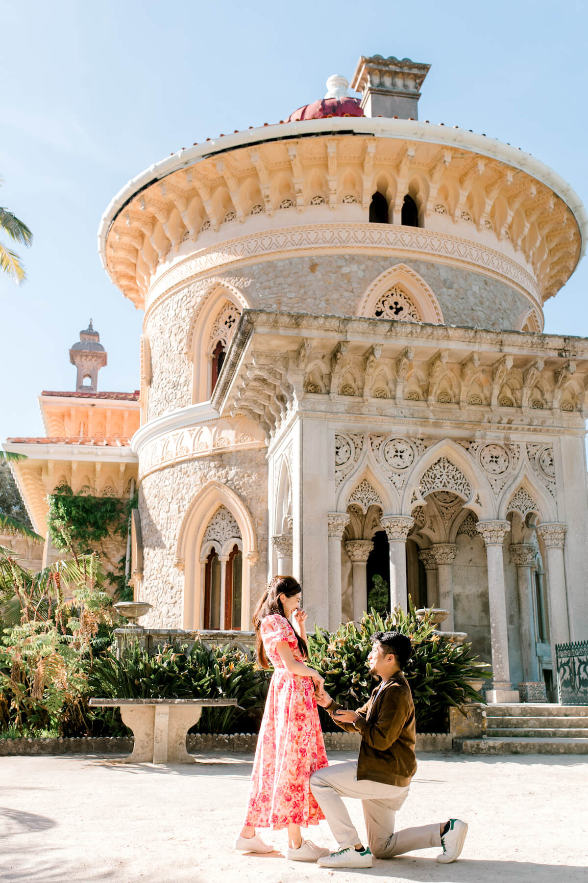 Woman wearing a red dress is being proposed to on a doc in Mauritius