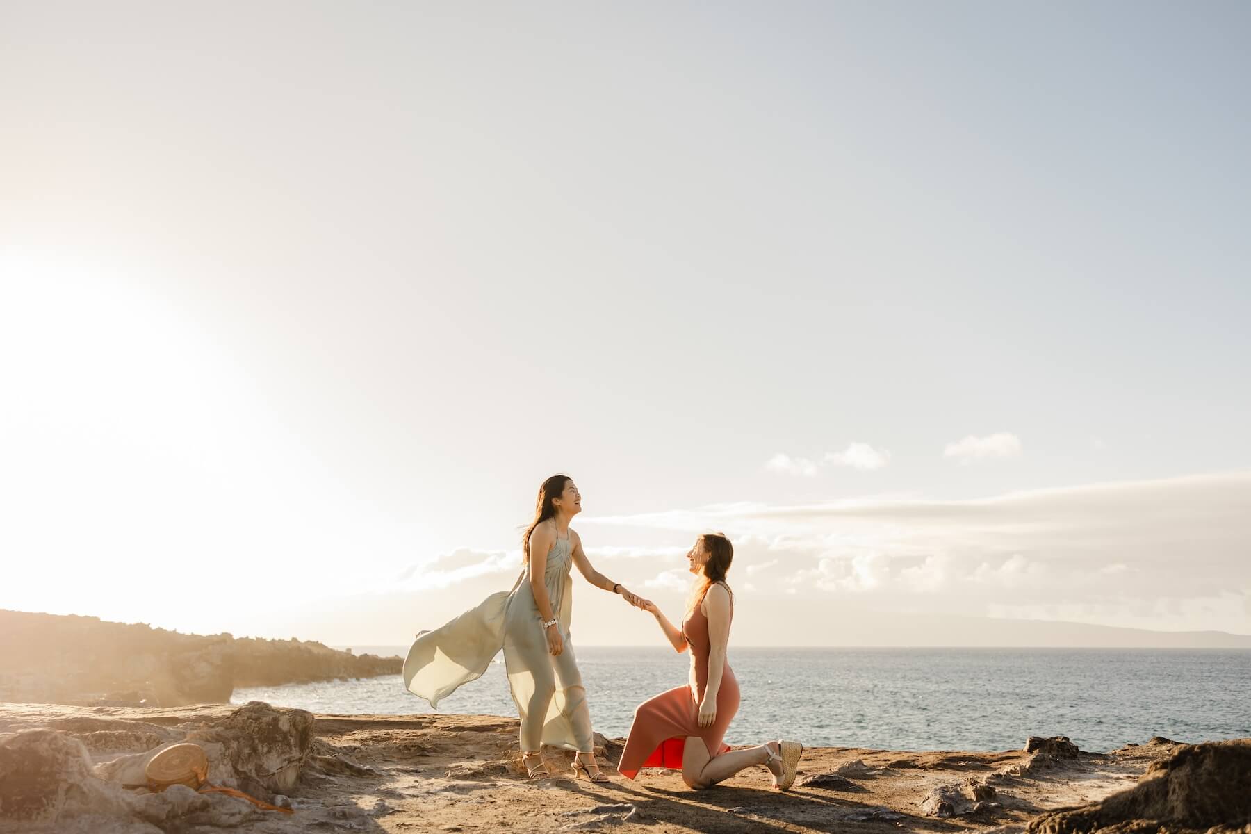 Woman wearing a red dress is being proposed to on a doc in Mauritius