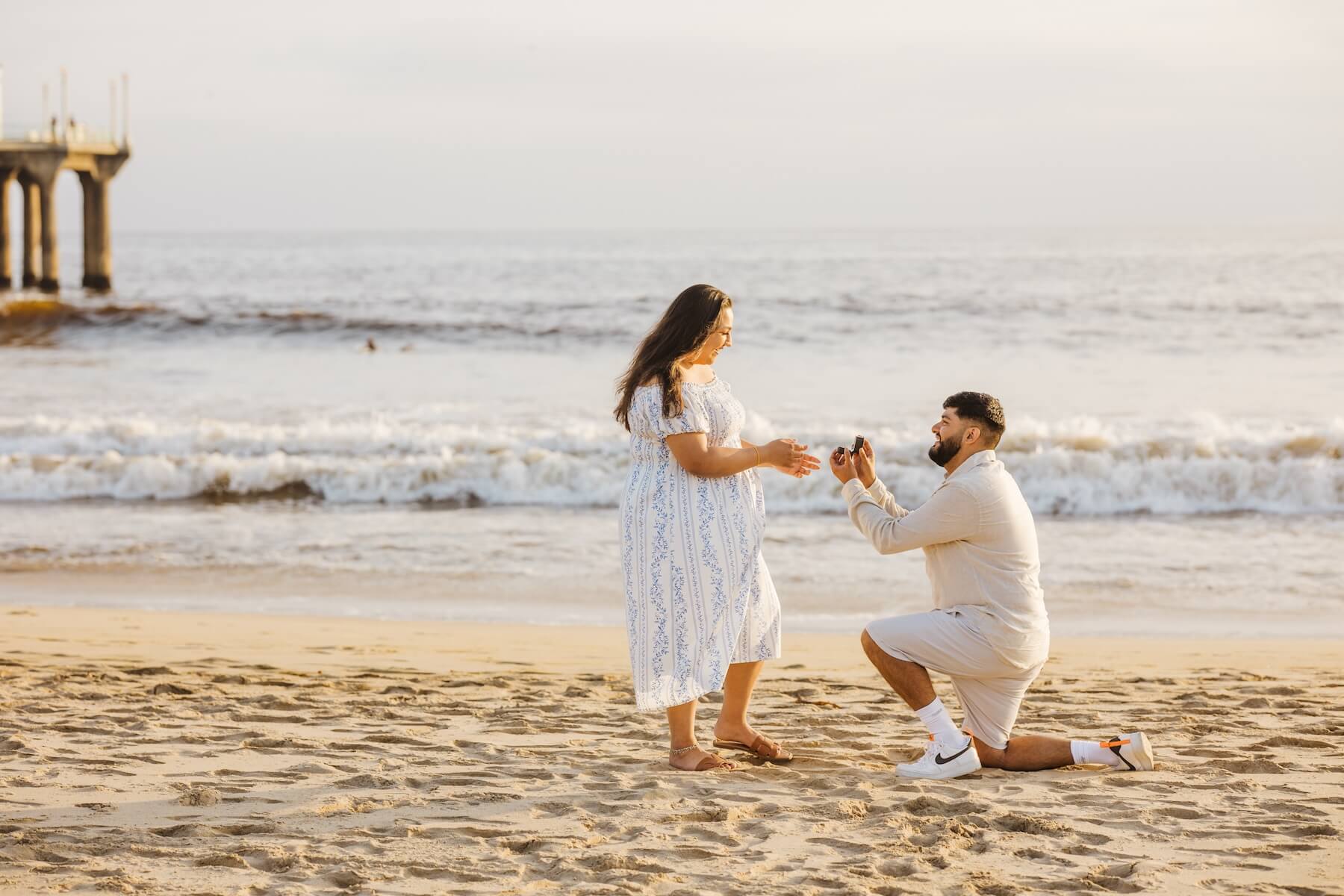 Woman wearing a red dress is being proposed to on a doc in Mauritius