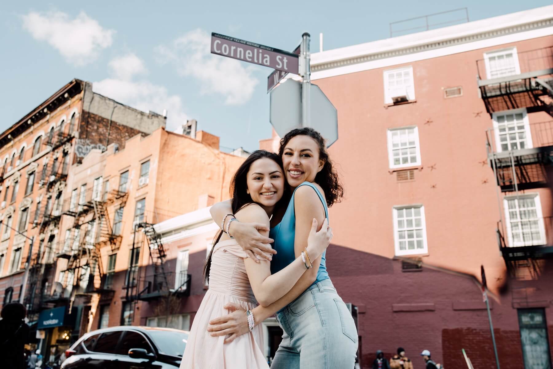 Friends hugging in front of Cornelia Street sign in NYC