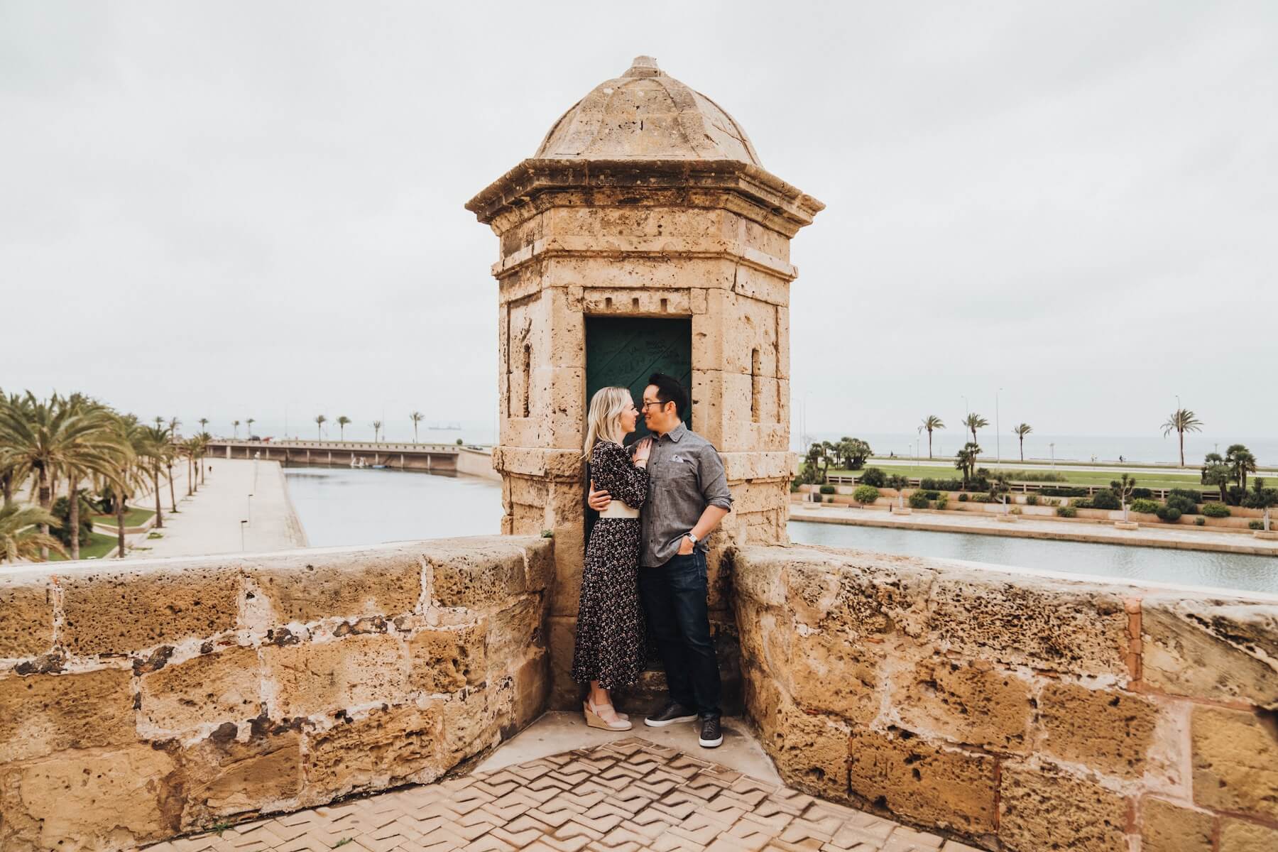 A couple hugs closely together about to kiss outside in Old Town in Palma de Mallorca.