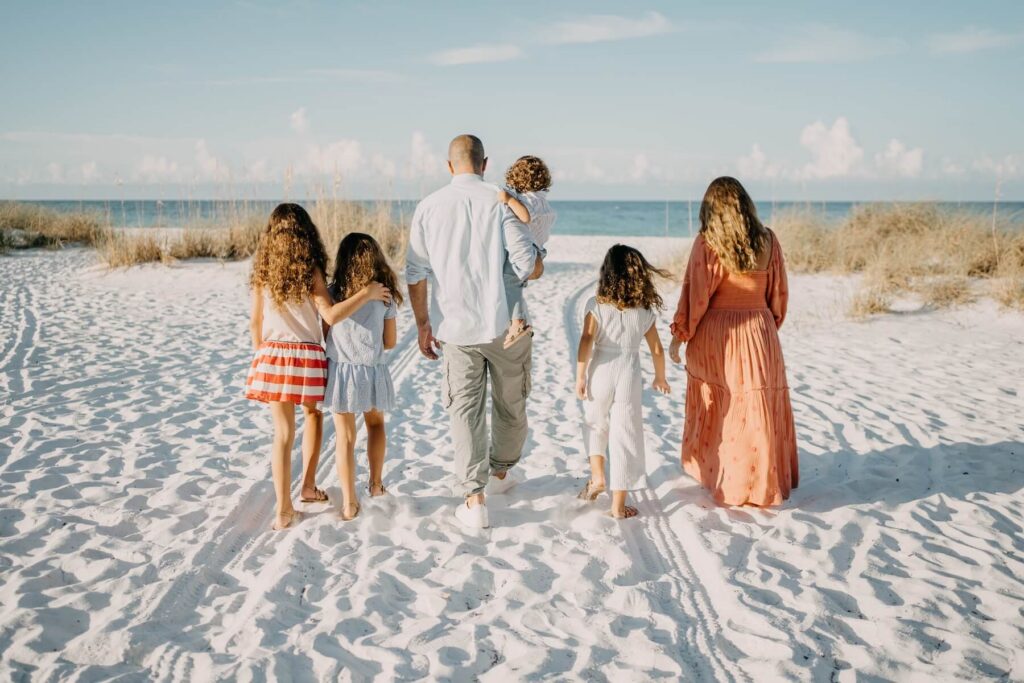 A family walking on the white sand beach in Sarasota on a family photoshoot with Flytographer.