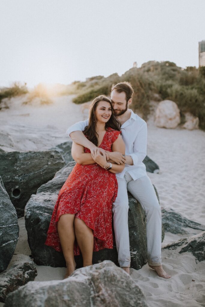 A couple sitting on the beach in Miami, Florida at  South Pointe Park & Beach
on a couples photoshoot with Flytographer.