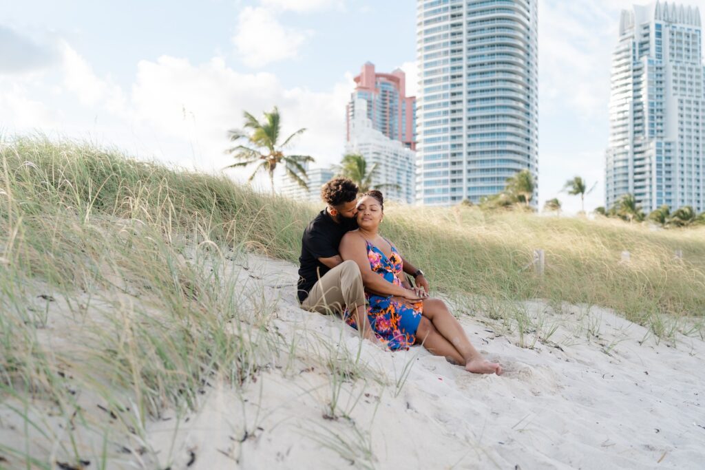 A couple cuddling on the beach in Miami, Florida at  South Pointe Park & Beach on a couples photoshoot with Flytographer.