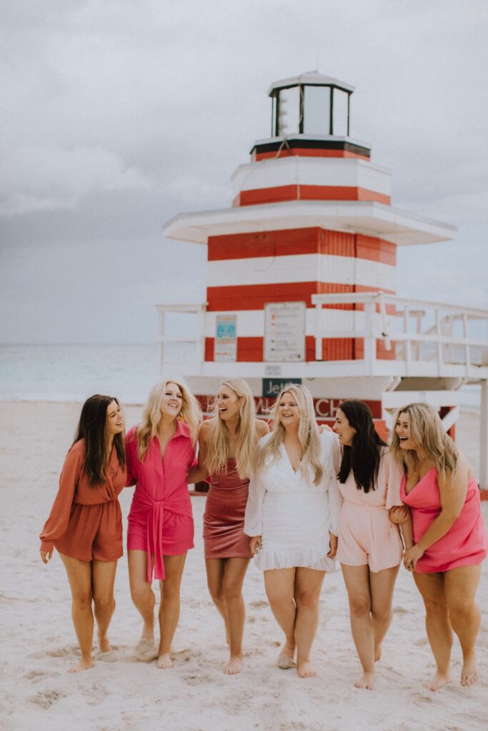 A group of friends walking on the beach in Miami, Florida at South Pointe Park & Beach on a bachelorette photoshoot with Flytographer.