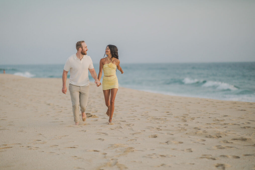 A couple walking on the beach in Todos Santos Mexico on a couples photoshoot with Flytographer.