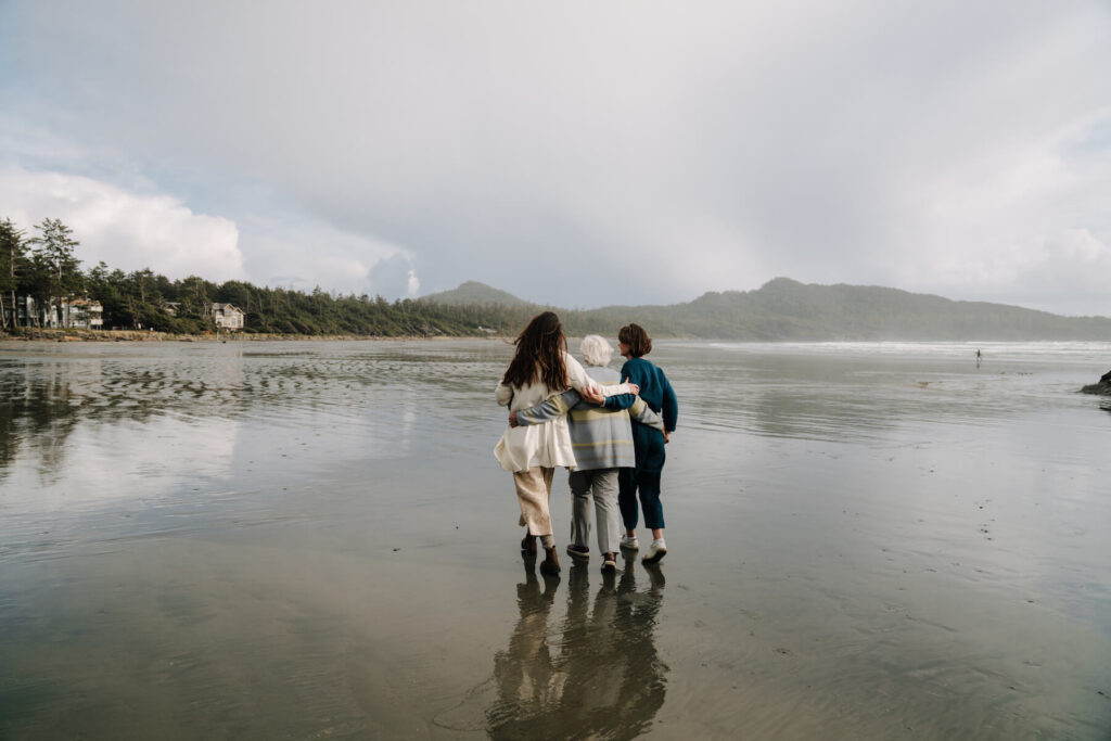 A family walking on the beach in Tofino, Canada on a family photoshoot with Flytographer