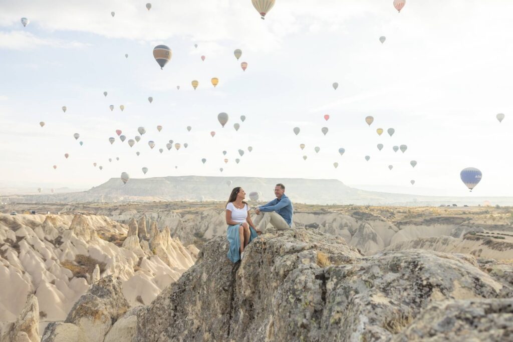 Couple sitting on the rocks in Cappadocia on a couples photoshoot with Flytographer
