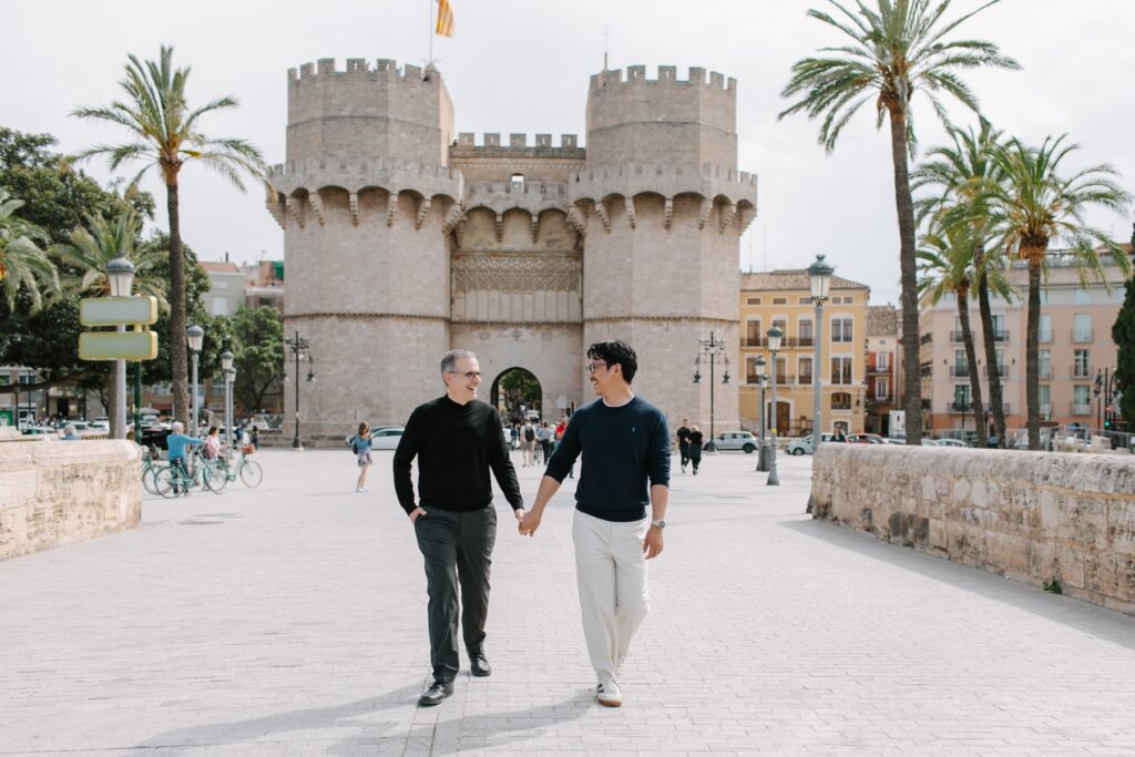 A couple walking in the streets of Valencia, Spain on a couples photoshoot with Flytographer.
