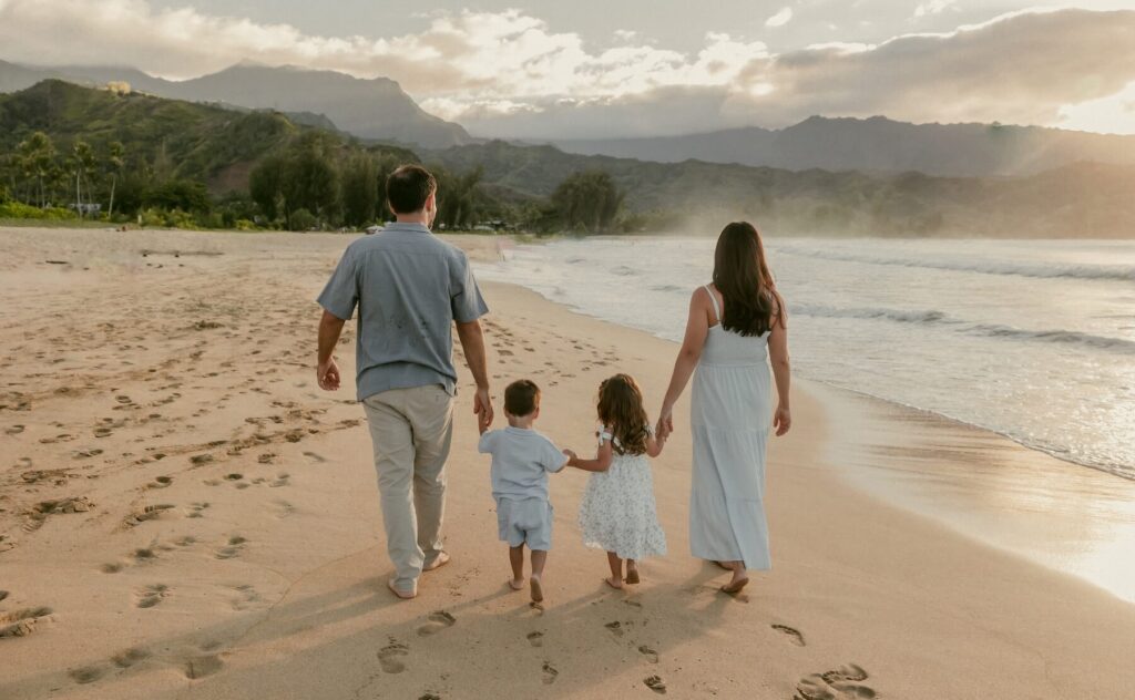 Family walking on the beach in Kauai Hawaii on a family photoshoot with Flytographer