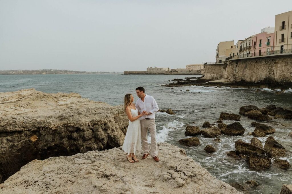 A couple walking in Syracuse on Sicily, which is one of the best places to visit in Italy, on a couples photoshoot with Flytographer.