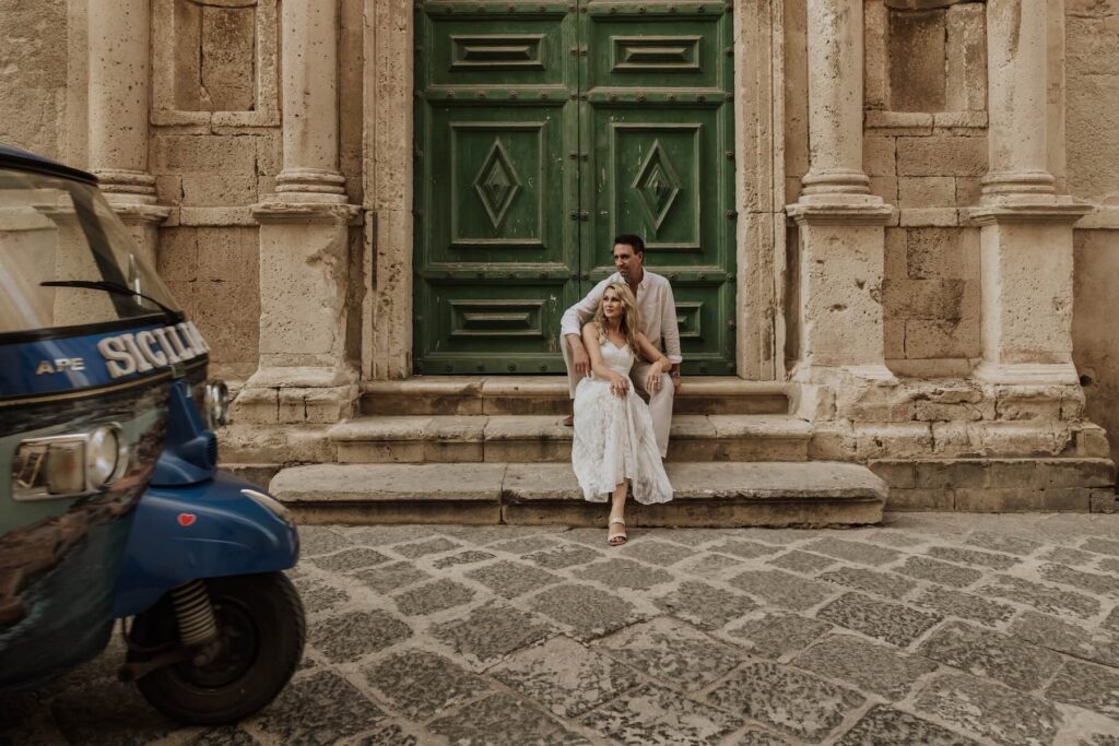 A couple walking in Syracuse on Sicily, which is one of the best places to visit in Italy, on a couples photoshoot with Flytographer.