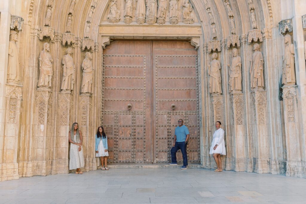 A family leaning against a door in Valencia, Spain on a family photoshoot with Flytographer.