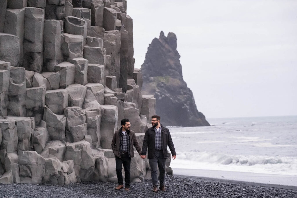Couple walking on the beach in Reykjavik Iceland on a couples photoshoot with Flytographer