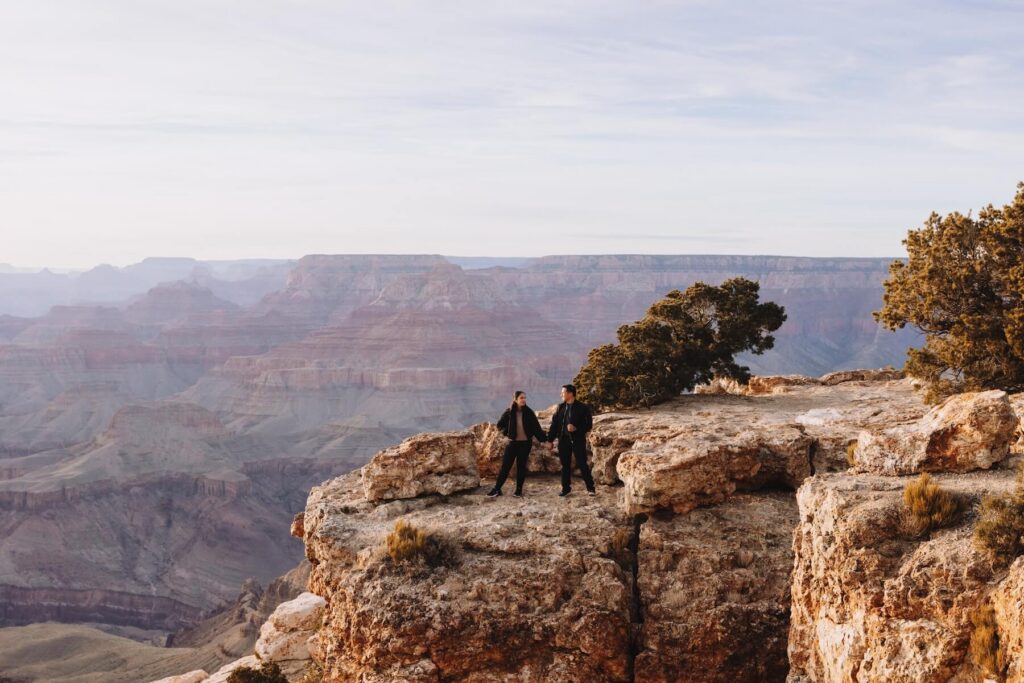 Couple holding hands in the Grand Canyon in Arizona on a couples photoshoot with Flytographer