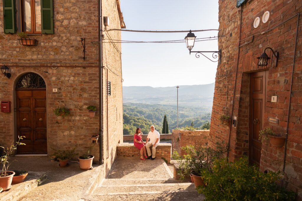 A couple sitting on a ledge in Umbria on a couples photoshoot with Flytographer.