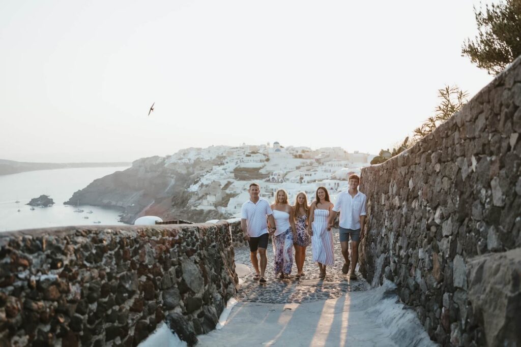 Family walking together in Santorini on a family photoshoot with Flytographer