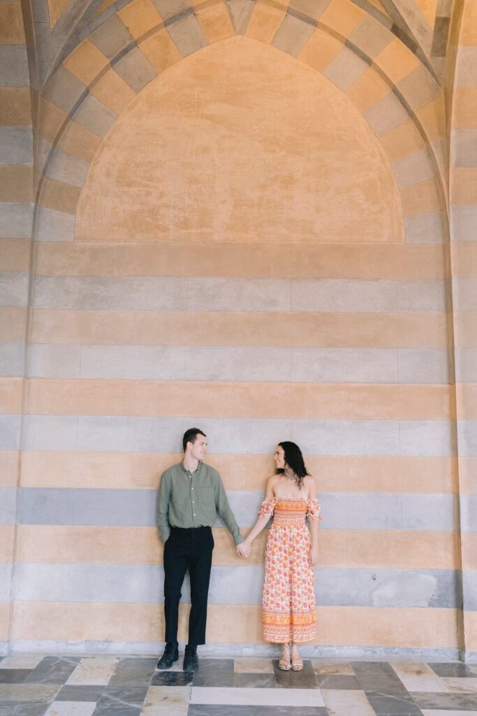 A couple walking on the beach in Amalfi Village on the Amalfi Coast, which is one of the best places to visit in Italy, on a couples photoshoot with Flytographer.
