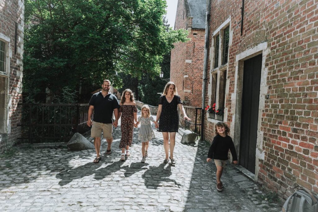 A family walking in the streets of Ghent, Belgium on a family photoshoot with Flytographer.