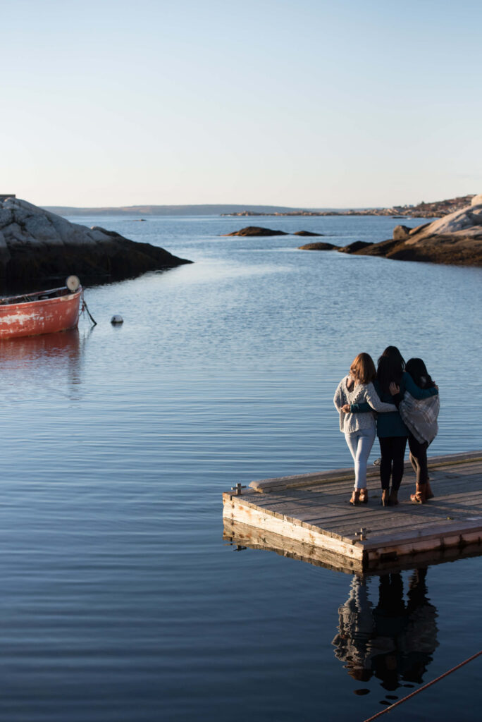 Friends capturing memories together near a lighthouse in Halifax, NS in the summer captured by Flytographer