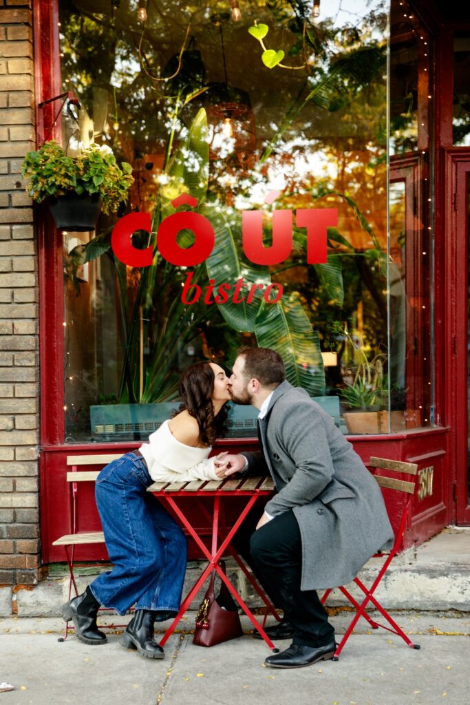 A couple kissing in front of Cout Bistro in Montreal, QC captured by Flytographer