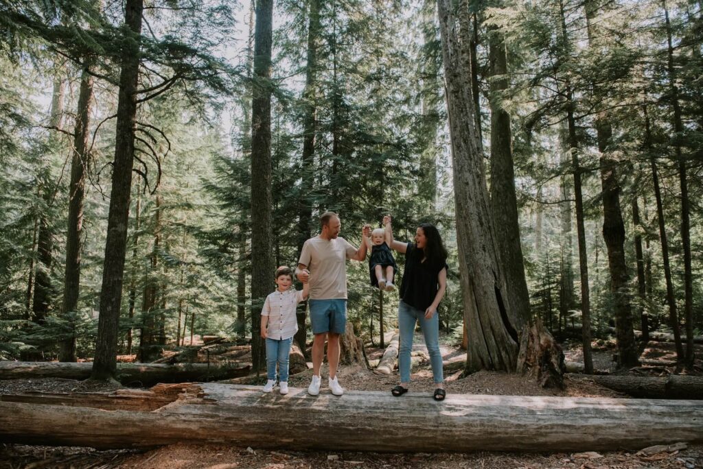 A family in the forest in Whistler, BC on vacation in Canada in the summer captured by Flytographer