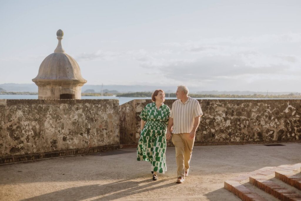 A couple walking on the wall in San Juan, Puerto Rico, one of the most European cities in North America on a photoshoot with Flytographer