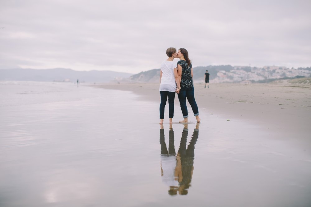 LGBTQ+ couple kissing on a beach in San Francisco, California, USA