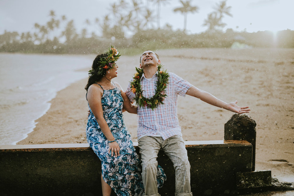 Couple laughing together in the pouring rain in Honolulu, Hawaii USA