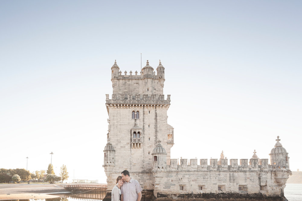 Couple hugging each other in front of castle on a couples trip in Lisbon, Portugal